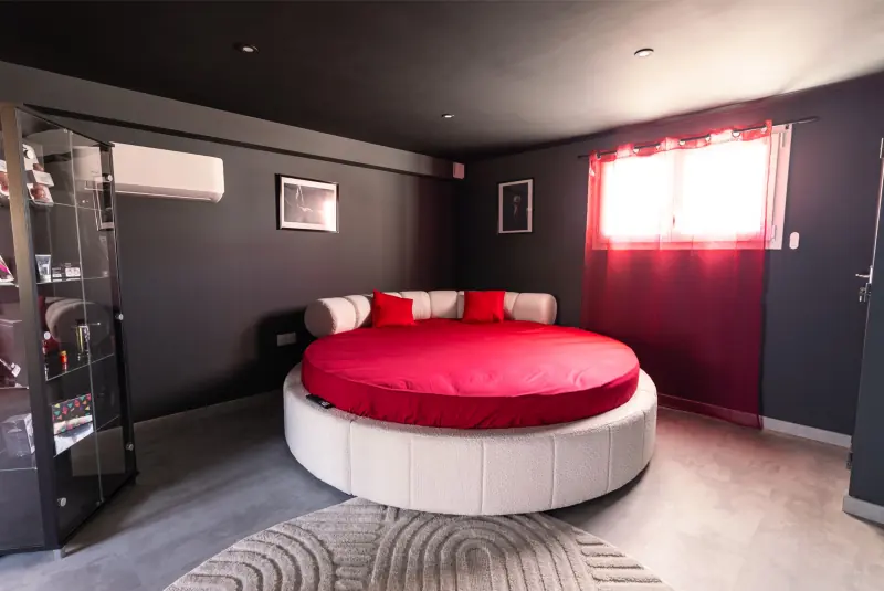Lit rond 220 cm aux draps rouges dans la suite L'Interdit