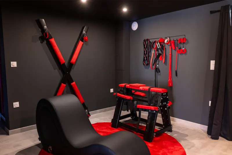 Salle au mobilier spécialisé rouge et noir de la suite L'Interdit
