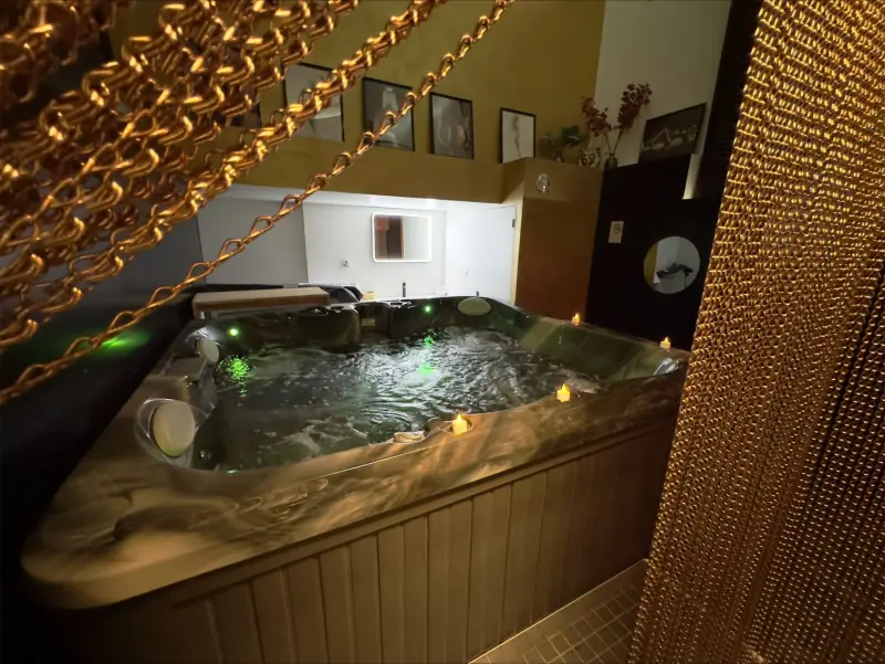 Jacuzzi entouré de rideaux de chaînes dorées et de guirlandes lumineuses