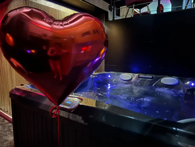 Ballon cœur rouge devant le jacuzzi d'une love room