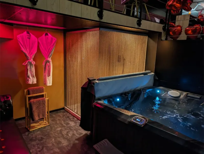 Love room La Black : spa privatif, rideau de chaînes dorées et peignoirs