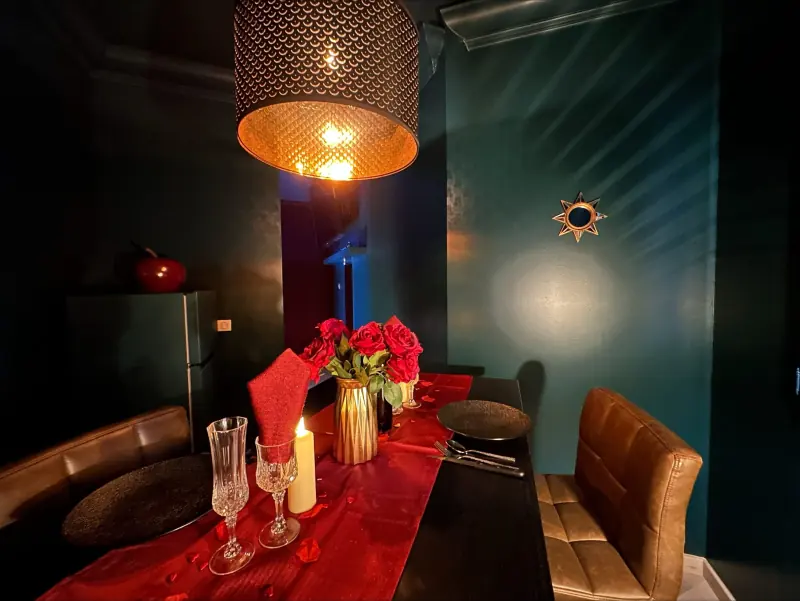 Table dressée avec roses et chandelles dans une love room à Bordeaux