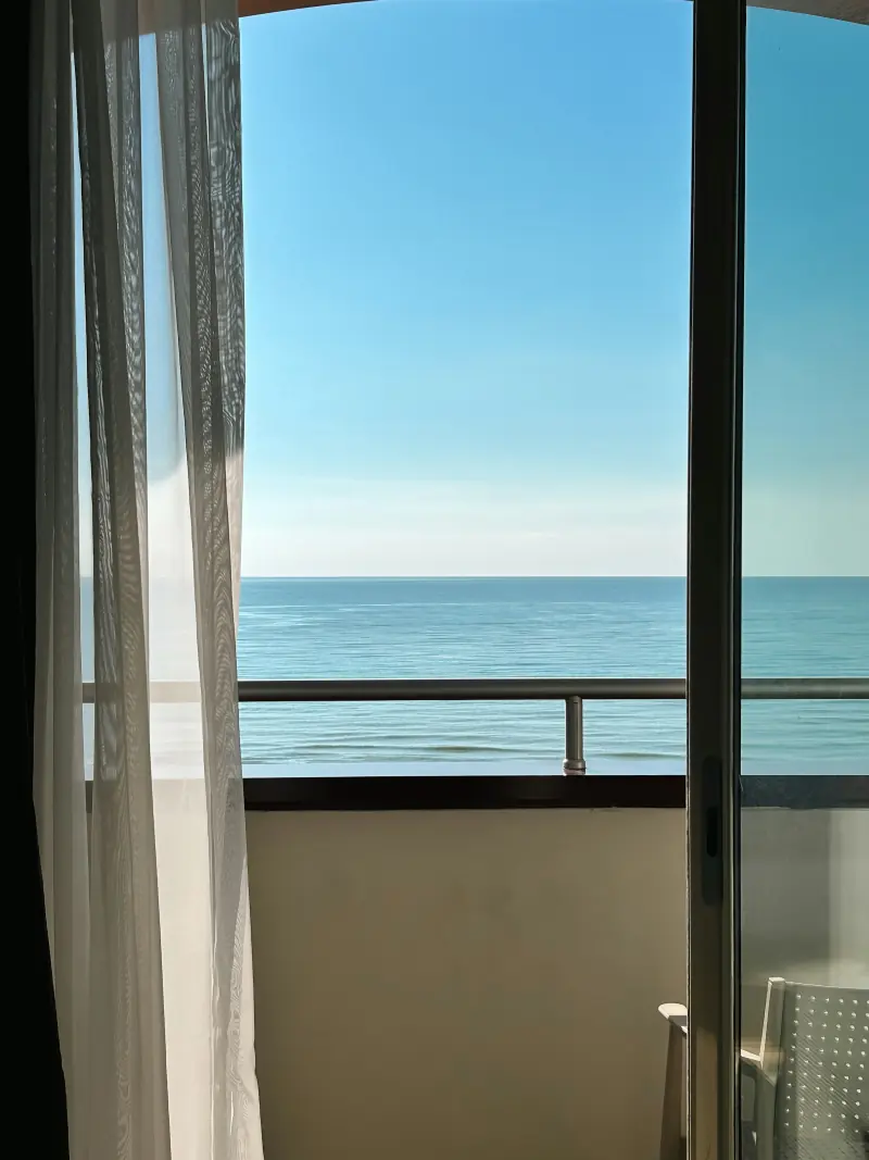 Balcon ouvert sur la mer, rideaux légers