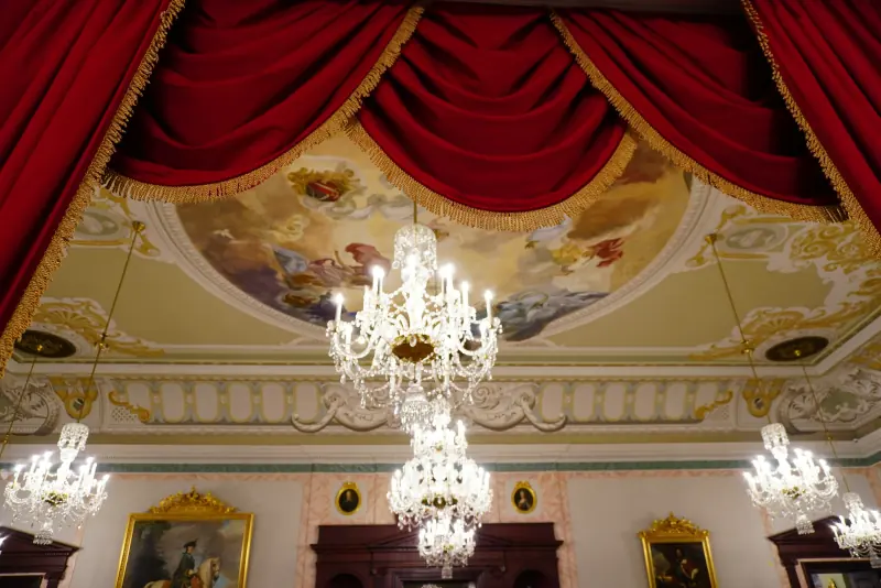 Salon baroque aux rideaux rouges et lustres de cristal