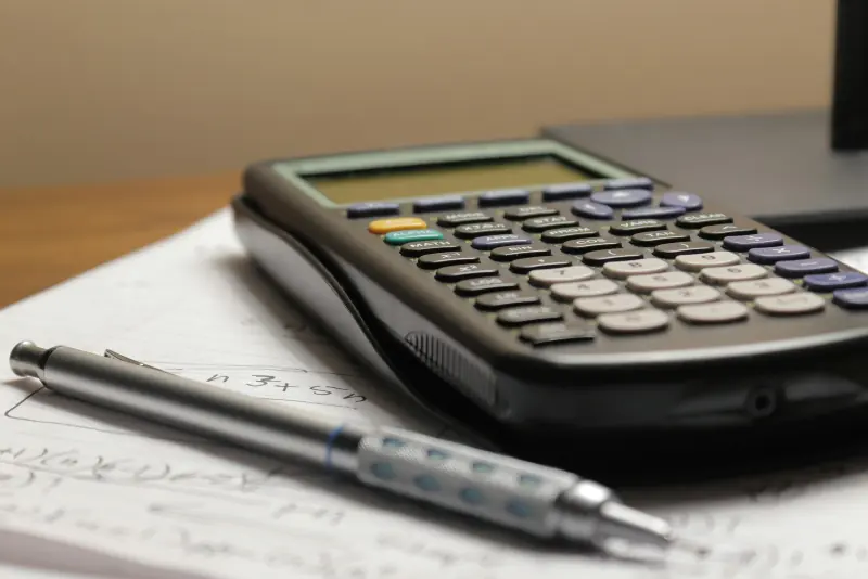 Calculatrice et stylo posés sur des documents
