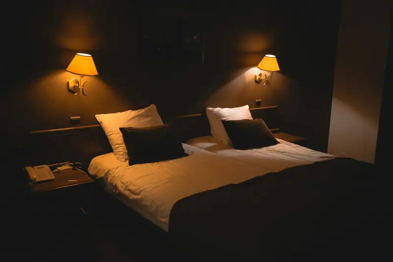 Chambre sombre éclairée par des lampes de chevet