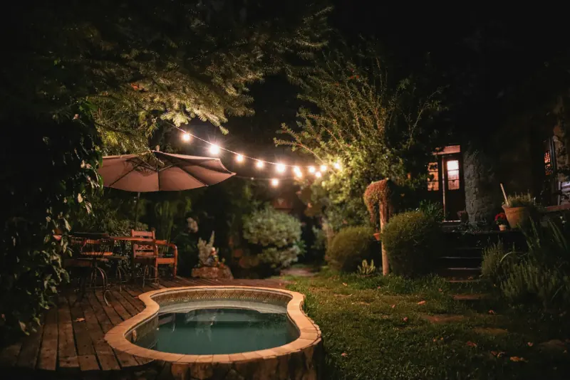 Jacuzzi extérieur illuminé de guirlandes la nuit