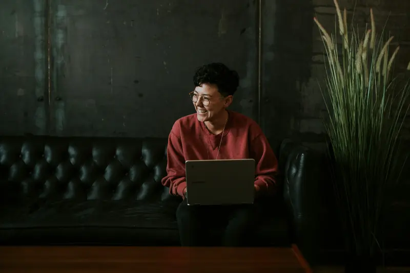 Entrepreneuse travaillant sur son ordinateur dans un salon sombre