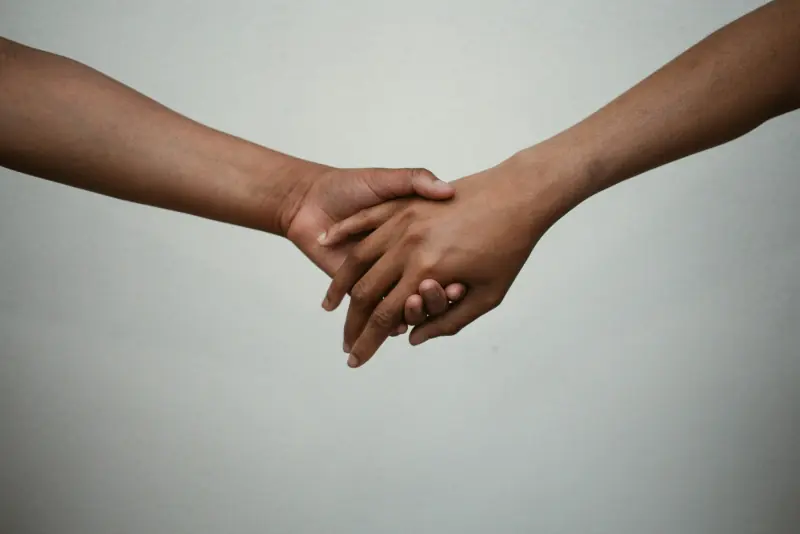 Deux mains de couleurs de peau différentes qui se tiennent